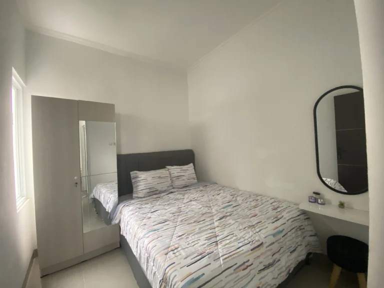 Kamar tidur utama rumah Ganda Arum Residence 7 Bekasi dengan desain modern dan pencahayaan alami.