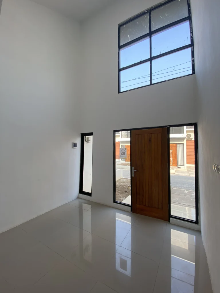 Interior ruang tamu rumah Ganda Arum Residence 5 Bekasi dengan jendela tinggi memberikan pencahayaan alami maksimal.